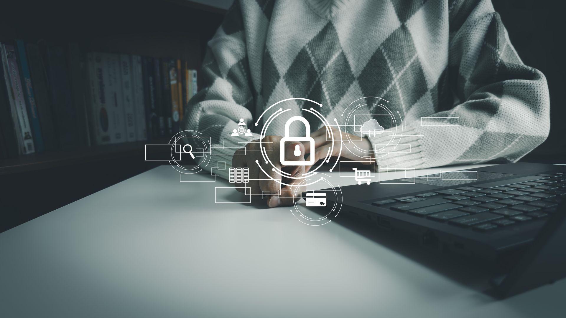 Person typing on a laptop with digital security icons overlaid, symbolizing cybersecurity and online protection.